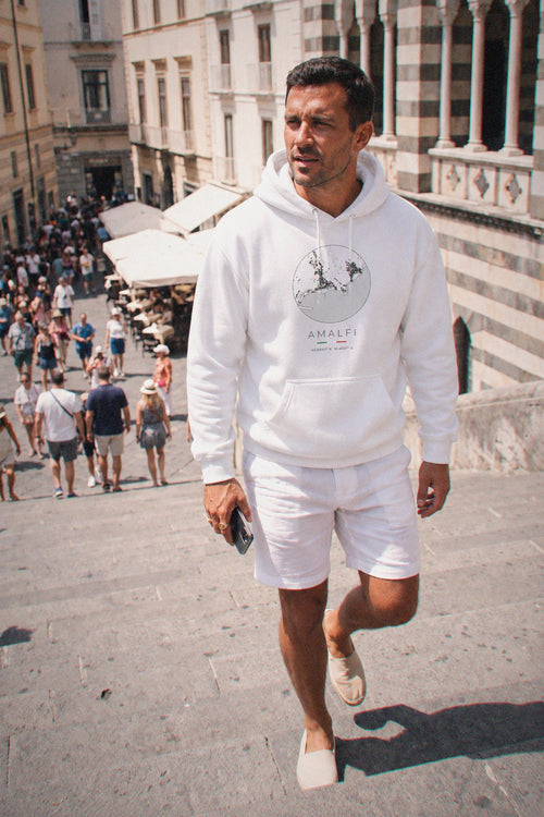 A man wearing the white hoodie carrying the real street map of Amalfi as a circle, photographed in Amalfi