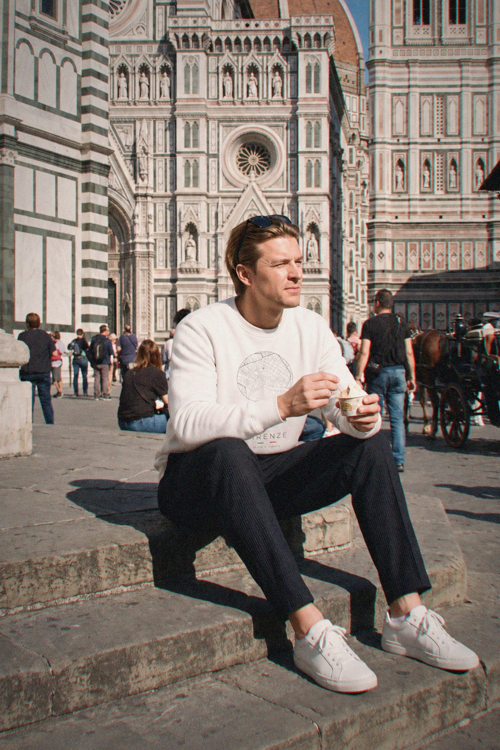 A man wearing the white crewneck sweatshirt carrying the real street map of Florence as a circle, photographed in Florence
