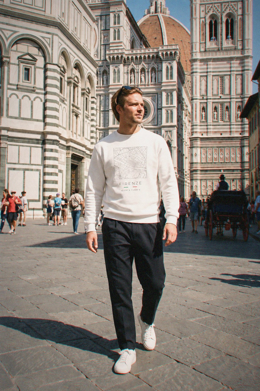 A man wearing the white crewneck sweatshirt carrying the real street map of Florence as a square, photographed in Florence