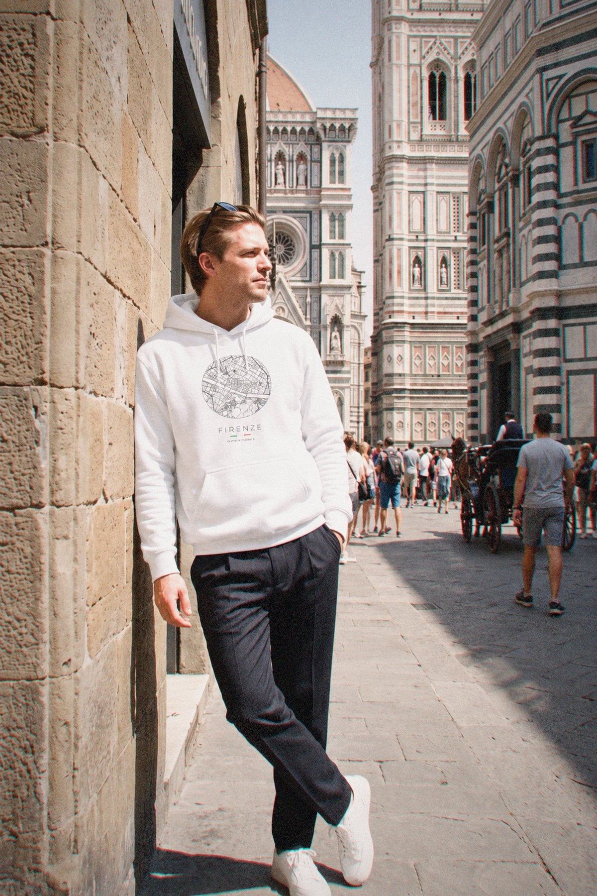 A man wearing the white hoodie carrying the real street map of Florence as a circle, photographed in Florence