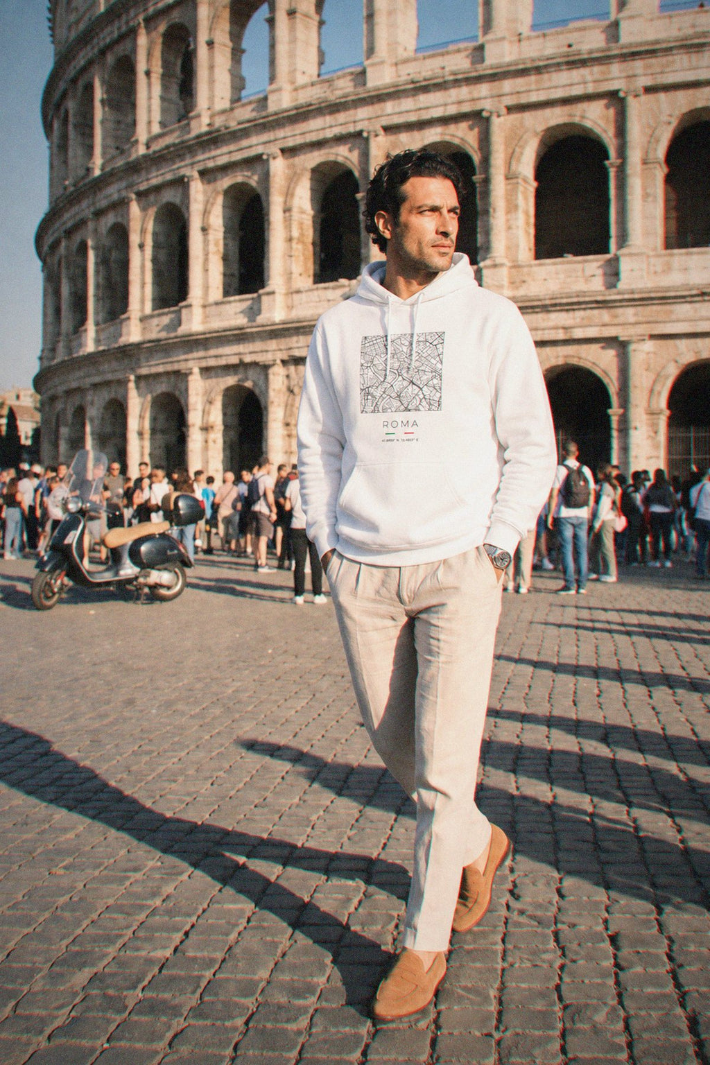 A man wearing the white hoodie carrying the real street map of Rome as a square, photographed in Rome